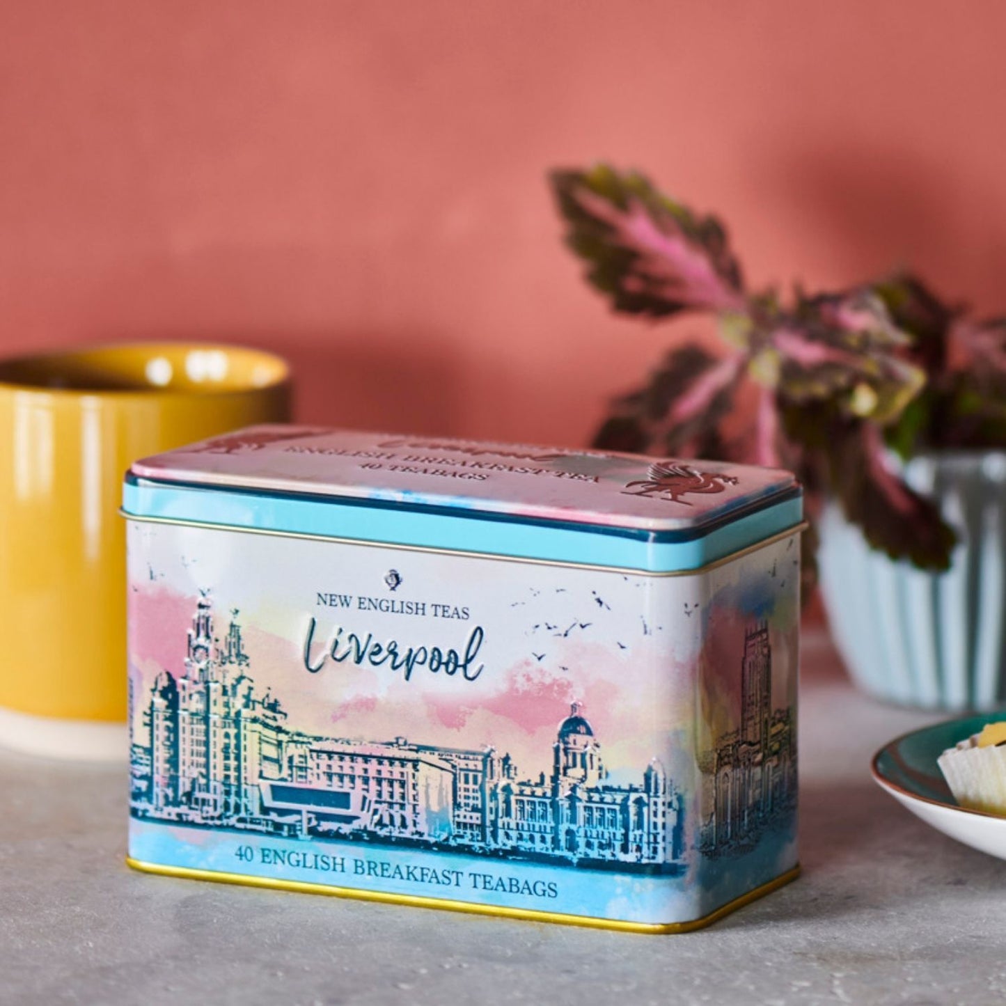 This tea tin features a watercolour print, beautifully capturing Liverpool's waterfront, where the iconic mercantile buildings, known as The Three Graces - The Royal Liver Building, Cunard Building and the Port of Liverpool Building - stand on the Pi