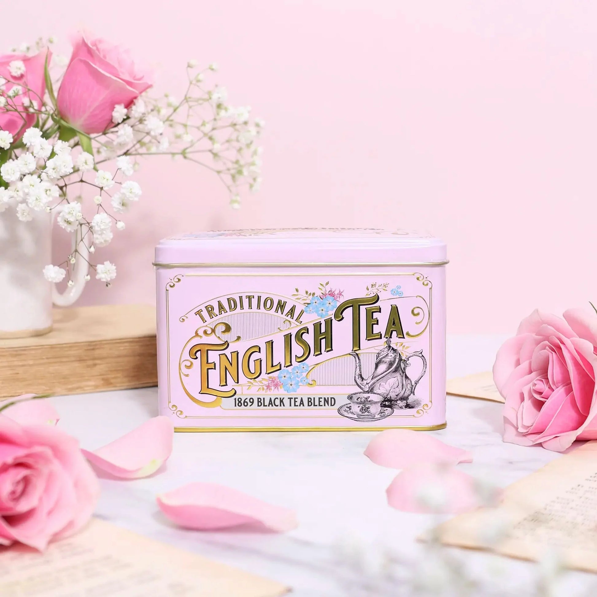 A rose-pink Vintage Victorian style tea tin featuring Victorian tea ware illustrations, gold trimming, embossing and azure blue Forget-Me-Not florals. Forget-Me-Nots became a symbol of love and remembrance for the Victorians and it was during this er